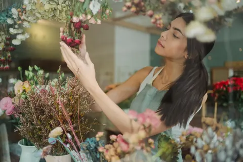 Florist arranging a bouquet in her shop